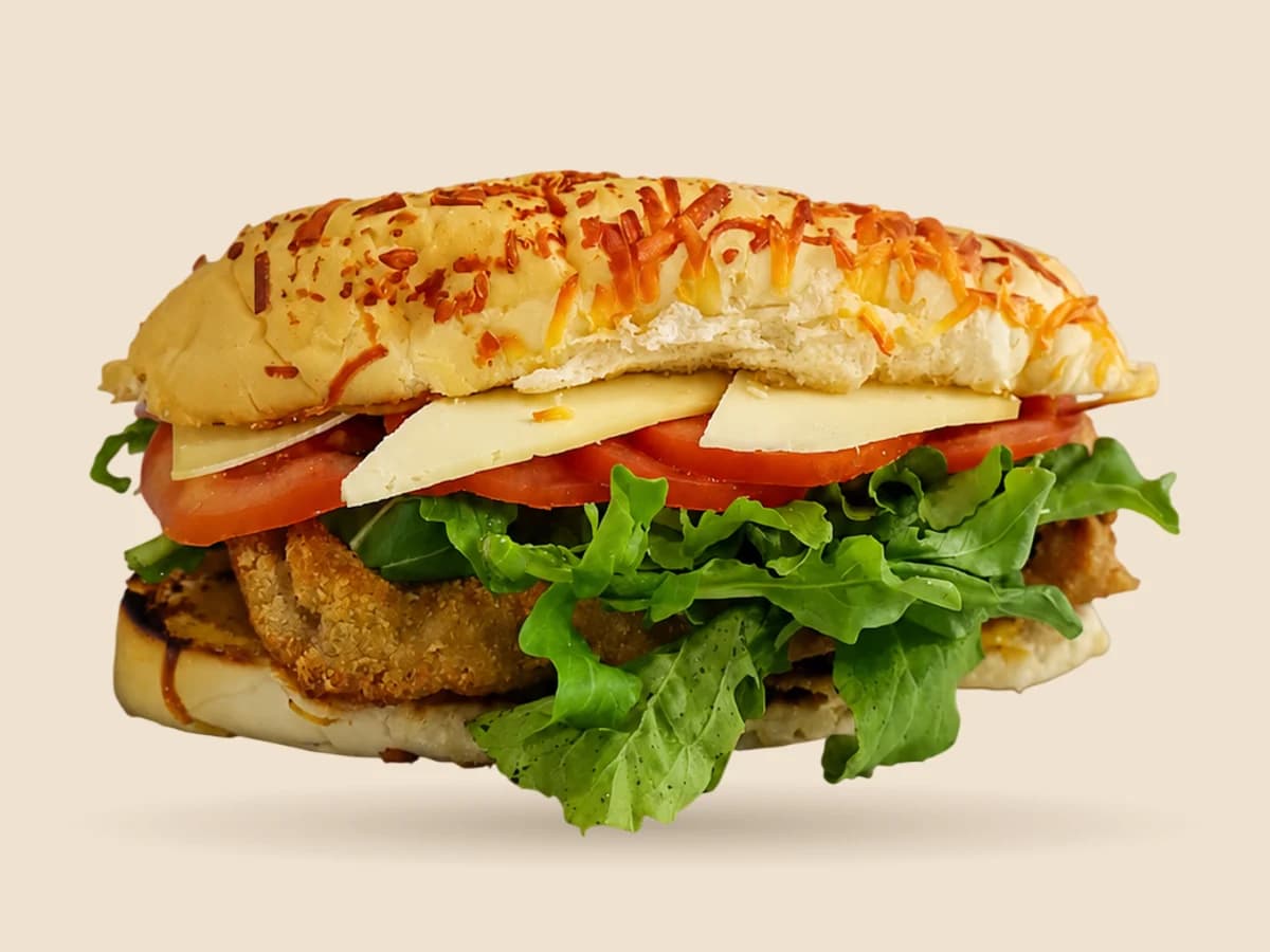 Milandwich de carne: milanesa, queso sardo, rúcula y tomate en pan de lomo gratinado